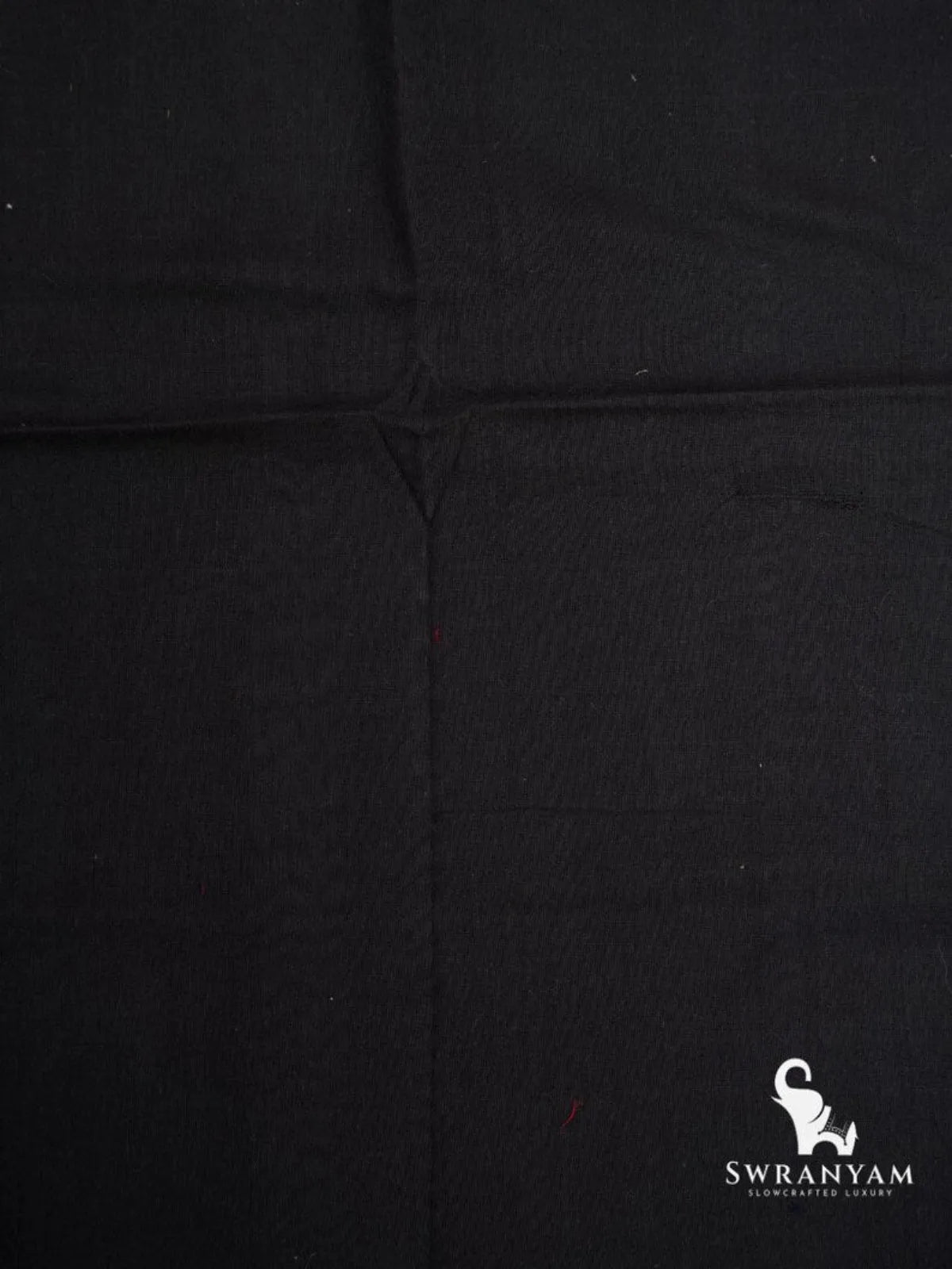 Close up of plain black handwoven cotton fabric texture of ikat saree