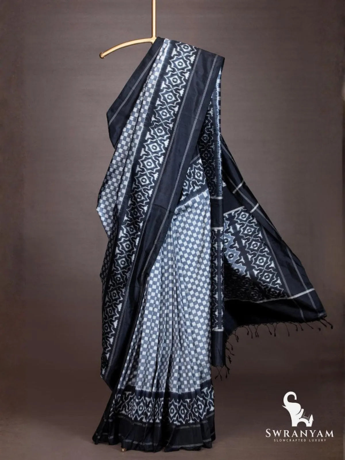 Full drape of handloom black grey ikkat silk saree with flowing geometric ikat pallu and black tassels