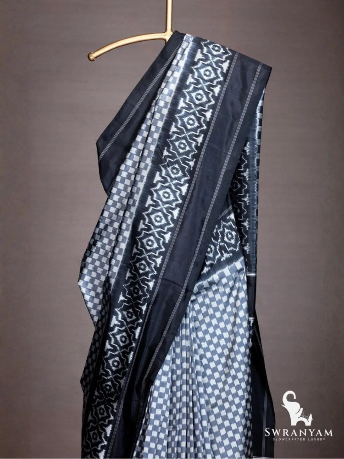 Close up of black geometric ikat border with white star motifs on grey checker Pochampally silk saree