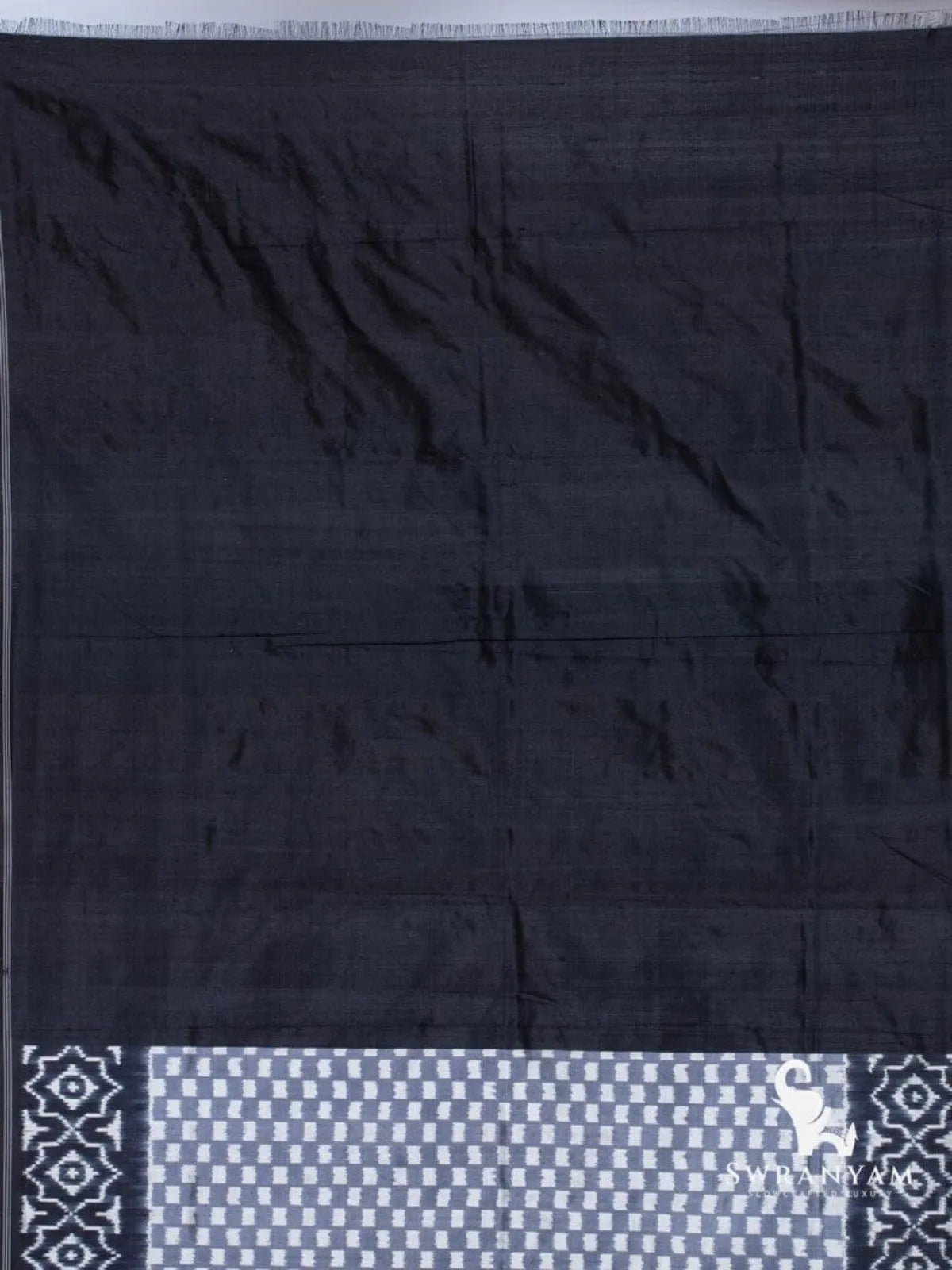Plain black silk end of handloom ikkat saree with grey checker and geometric ikat border detail