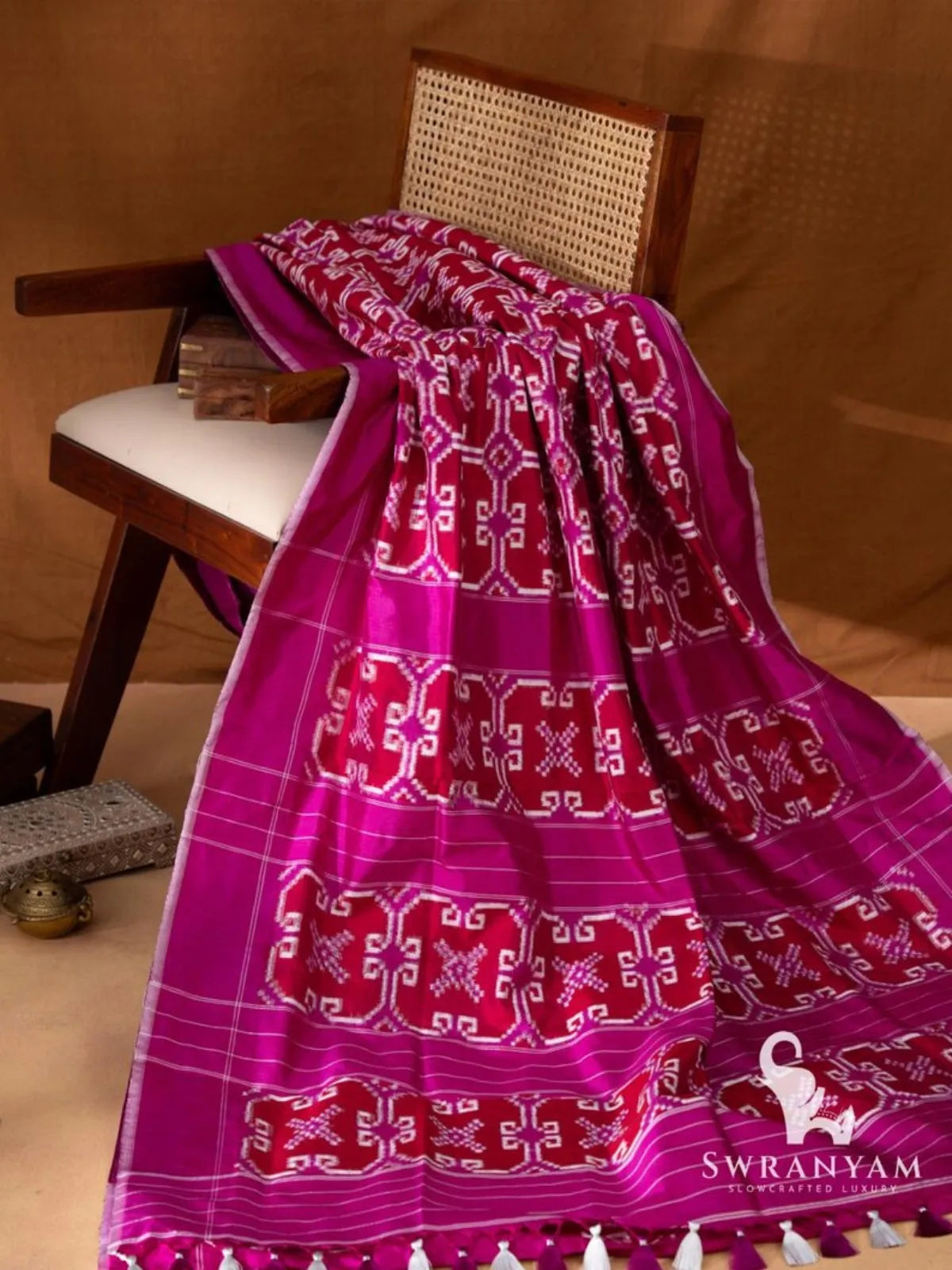 Crimson red Pochampally double ikat silk saree with white and magenta geometric ikat motifs and magenta border on chair