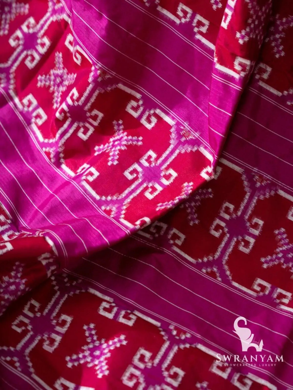 Close-up of red double ikat motif bands between magenta pinstriped sections on the pallu of a Telia Rumal silk saree