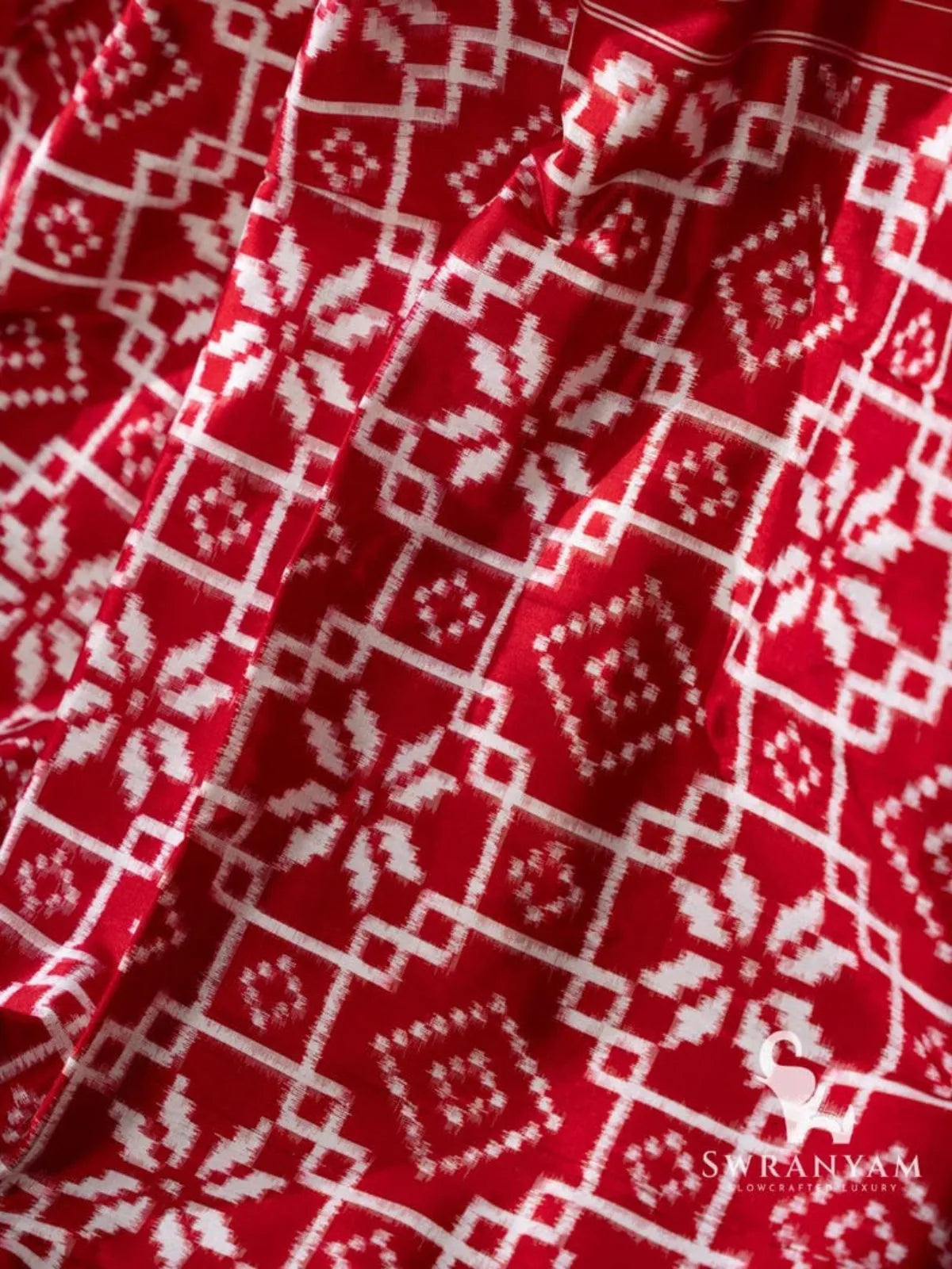Close-up of white double ikat lattice, diamond and star motifs on red silk pallu of Telia Rumal saree