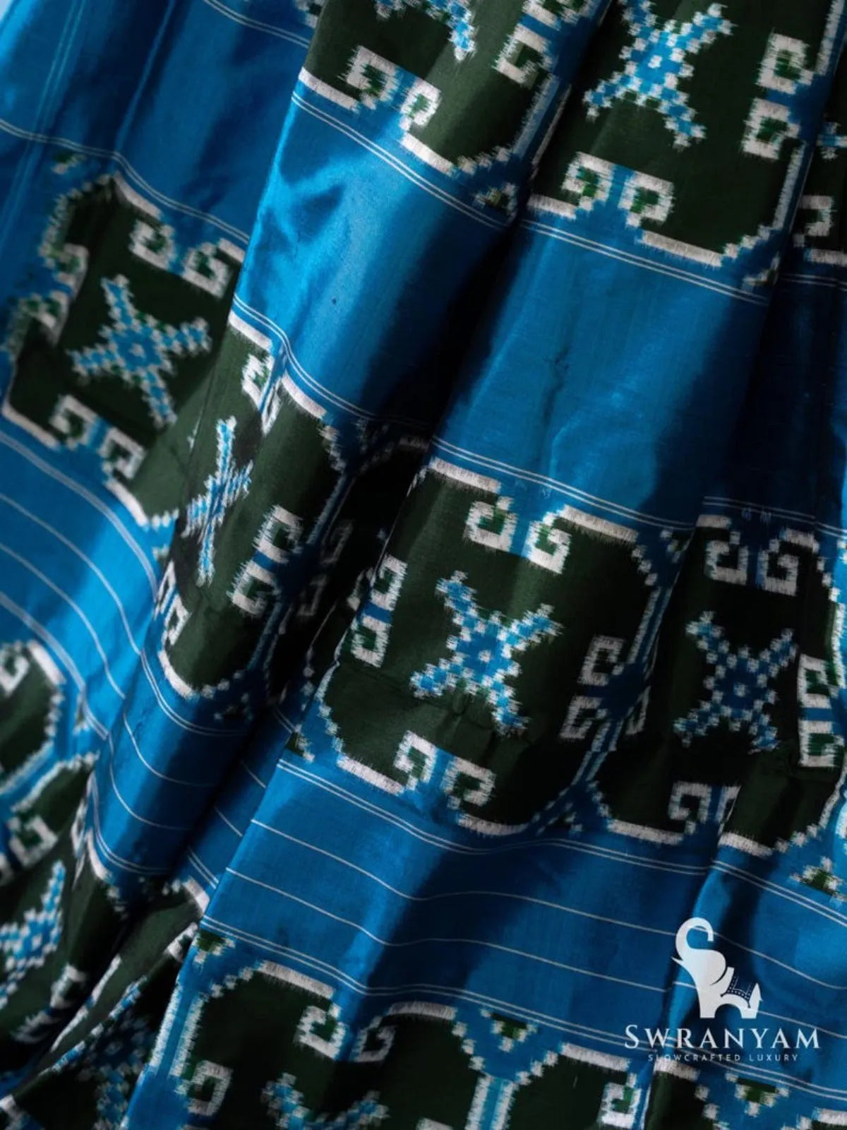 Close-up of blue pallu with green double ikat motif panels and thin white pinstripes on Telia Rumal silk saree