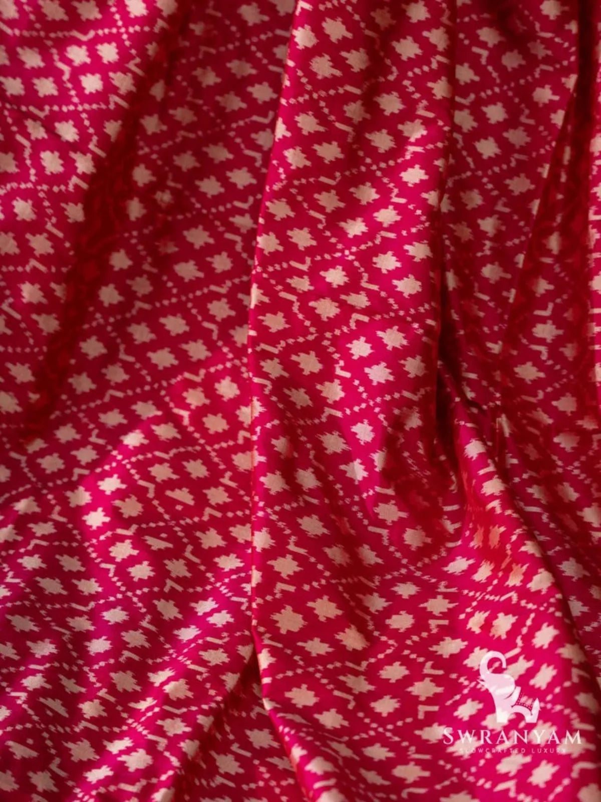Close-up of white diamond and star ikat motifs on pink Pochampally silk saree fabric