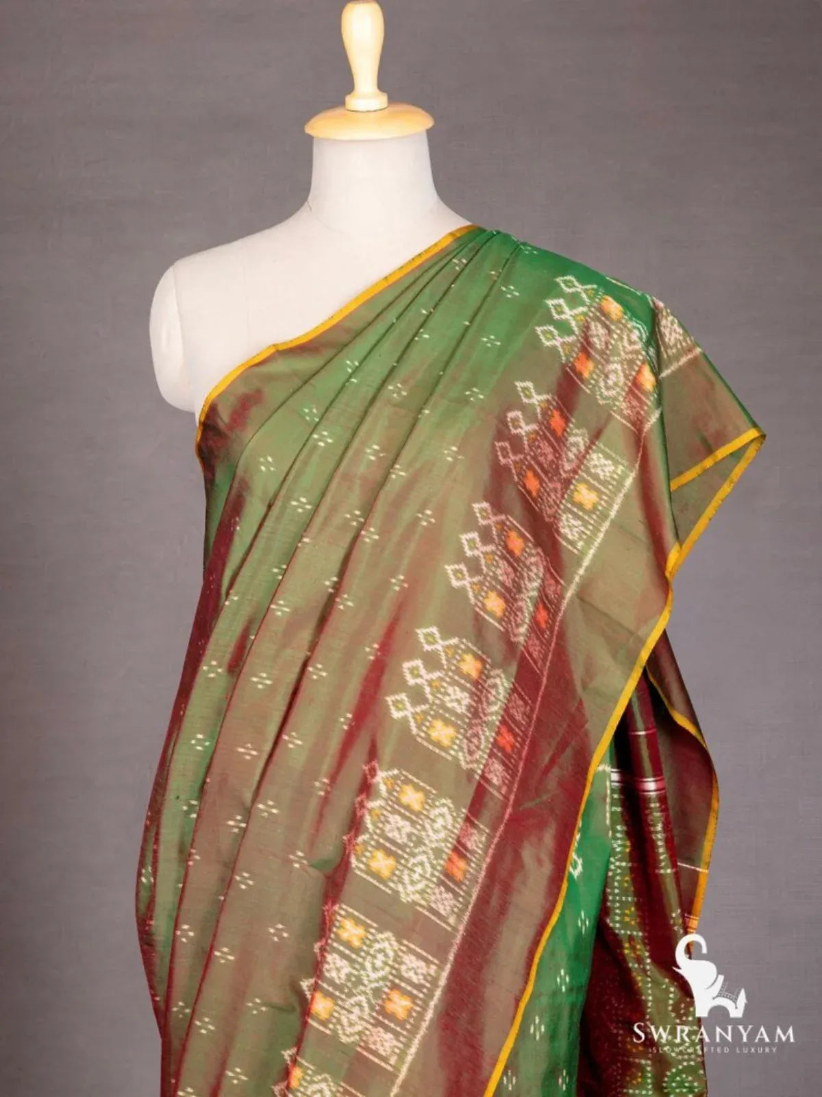 Close-up of Pochampally ikat silk saree pleats and shoulder with white orange ikat motifs and mustard edge