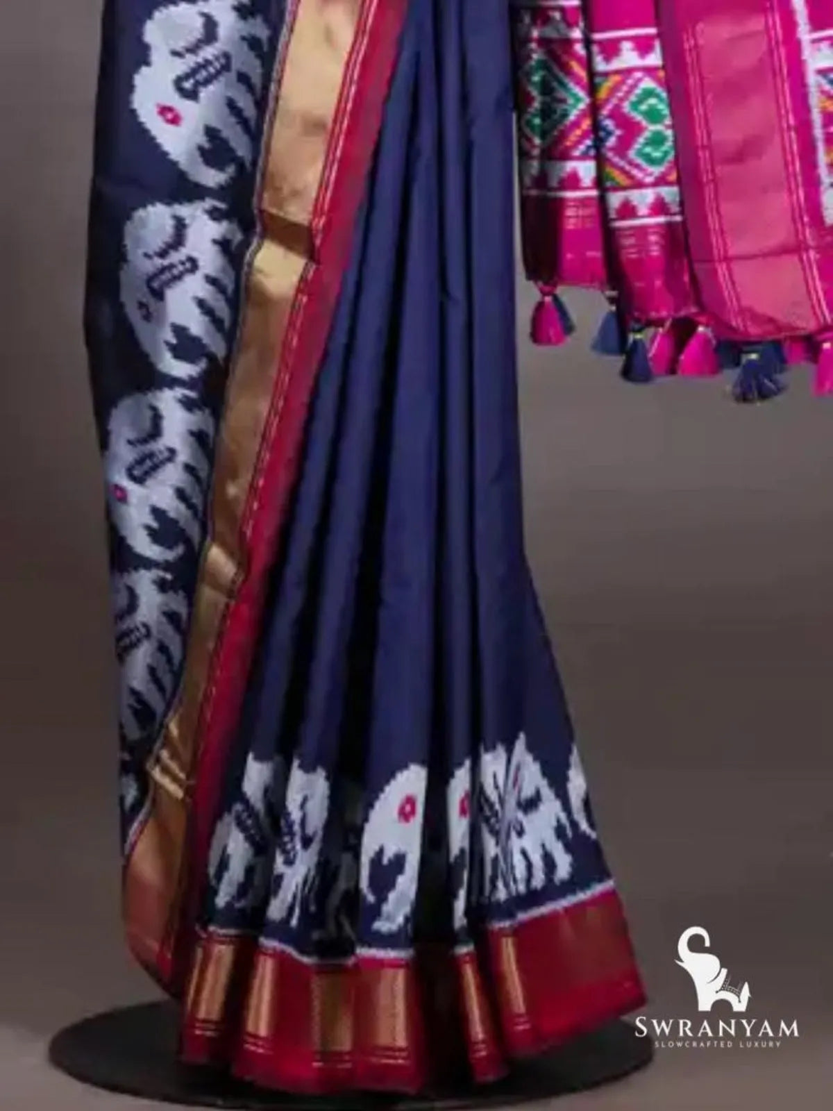 Navy blue ikat silk saree pleats with white elephant motif hem, gold zari border with maroon edging and pink pallu