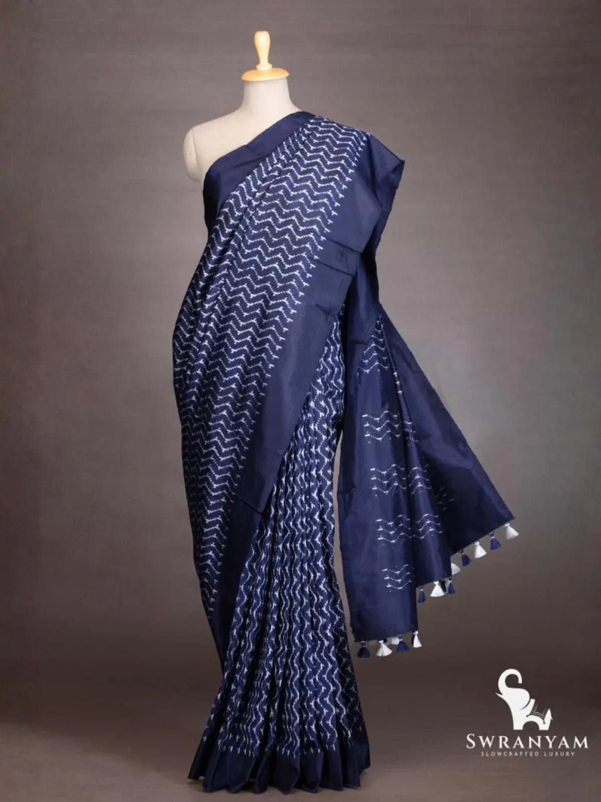 Indigo blue Pochampally ikat silk saree with white chevron motifs draped on mannequin, pallu with blue and white tassels