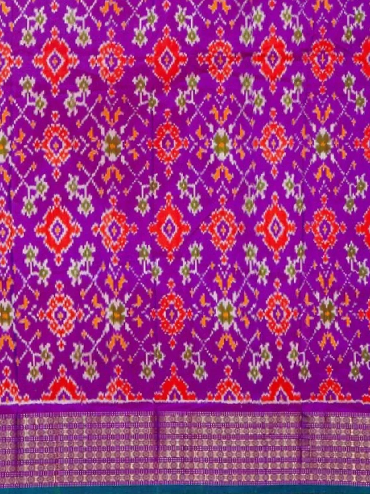 Purple ikat pallu with red, orange and white traditional motifs of orange twill ikat silk saree