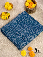 Folded handwoven indigo blue cotton ikat saree showing traditional white ikat motifs on the body