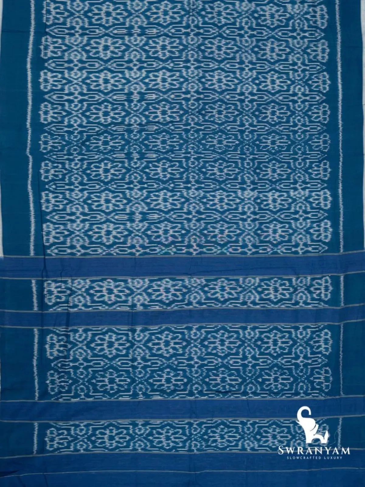 Flat lay of indigo blue Pochampally ikat cotton saree with floral jaal body and striped ikat pallu