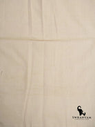Close up of plain ivory handwoven cotton fabric of grey and indigo ikat saree