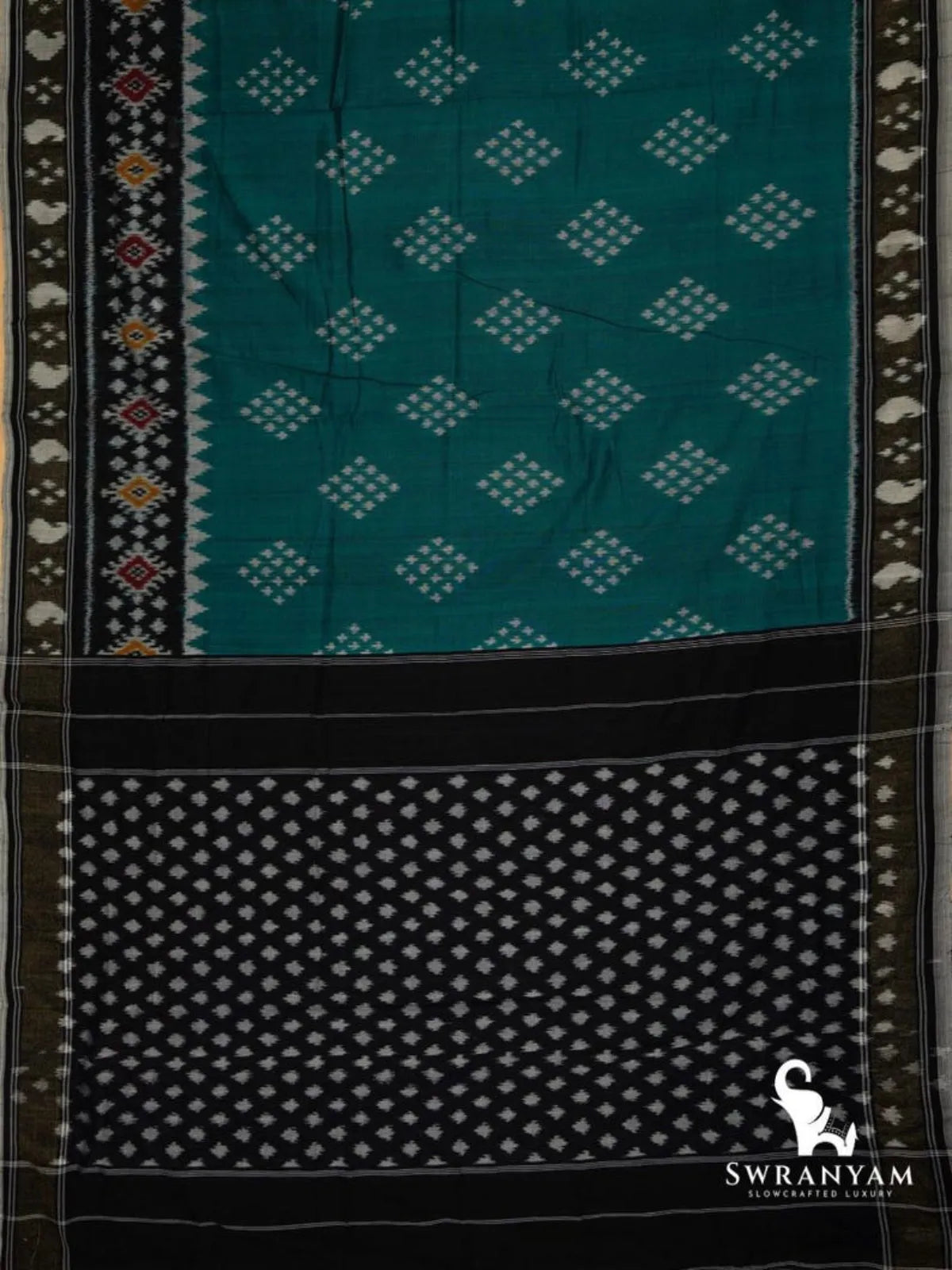 Flat lay of emerald green Pochampally ikat cotton saree with diamond butti body, black ikat border and black pallu