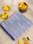 Folded handwoven sky blue cotton ikat saree showing white tree leaf motifs on the body