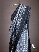 Close up of black geometric ikat border with white star motifs on grey checker Pochampally silk saree