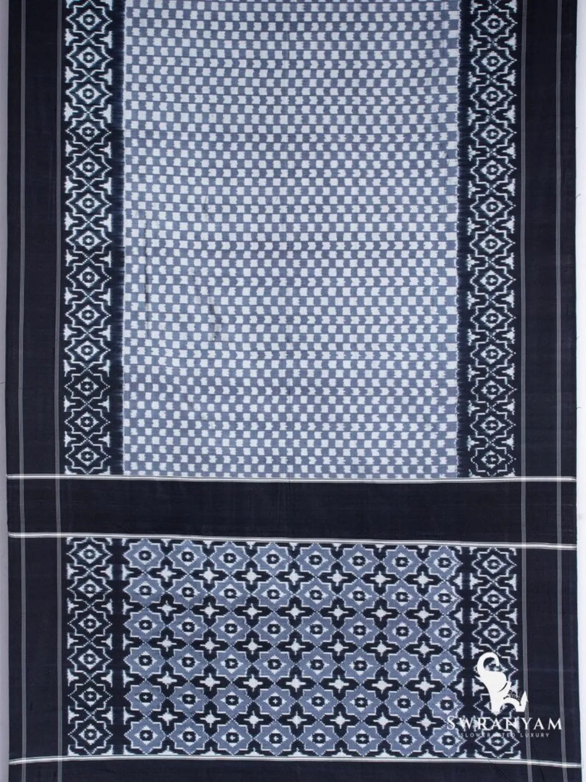 Flat lay of black grey Pochampally ikat silk saree showing checker body, geometric border and star motif pallu