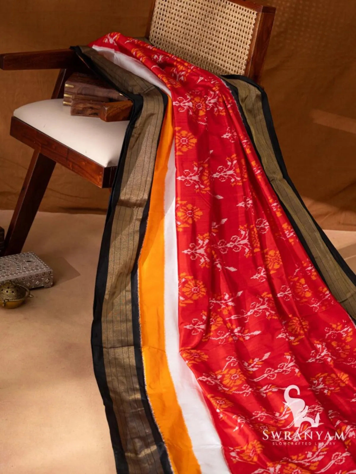 Full length drape of pure silk Pochampally ikat saree in red with yellow, white and black golden zari border