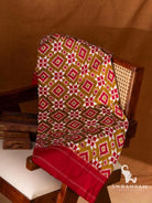 Olive green Pochampally Telia Rumal double ikat silk saree with red and white diamond motifs and red border folded