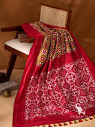 Olive green Telia Rumal double ikat silk saree with red pallu of white geometric ikat motifs and olive and red tassels