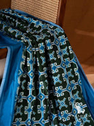 Bottle green Telia Rumal silk saree pleats with blue and white double ikat motifs beside blue border