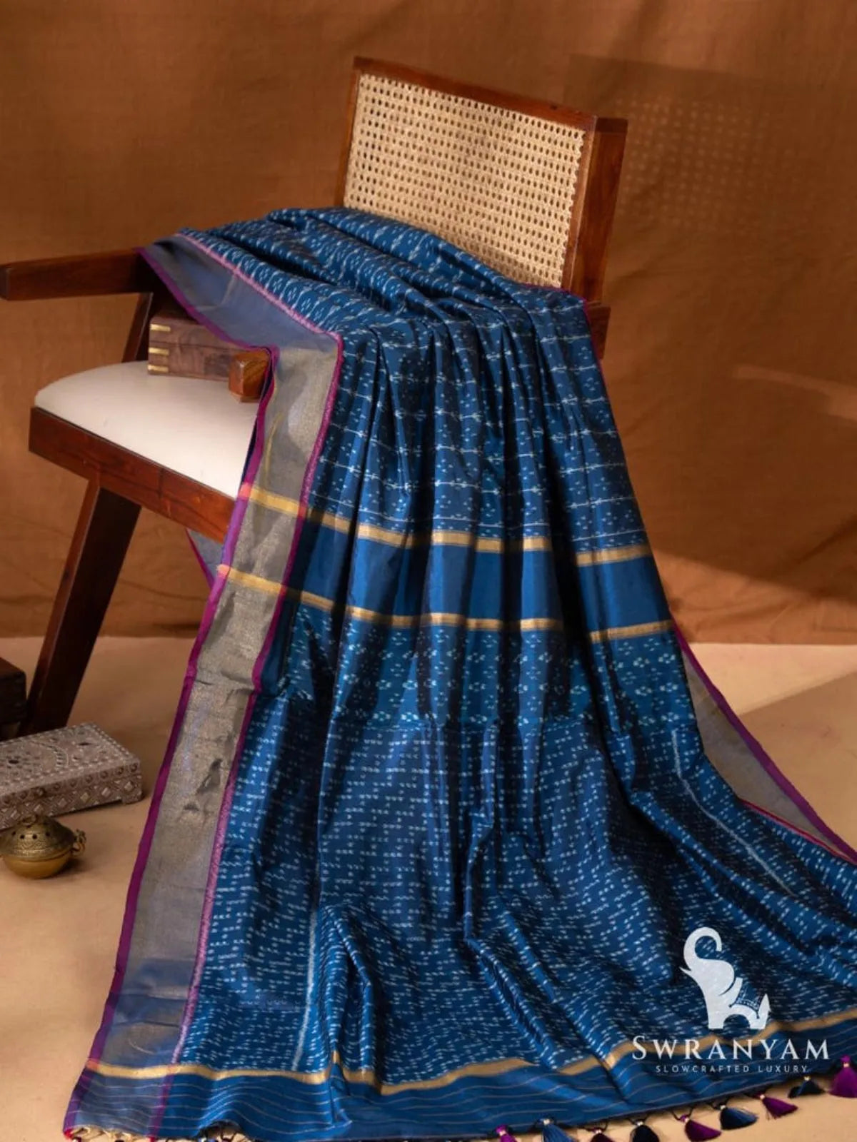 Indigo blue ikat silk saree with zari border and pink edging, pallu with gold zari bands and purple and navy tassels