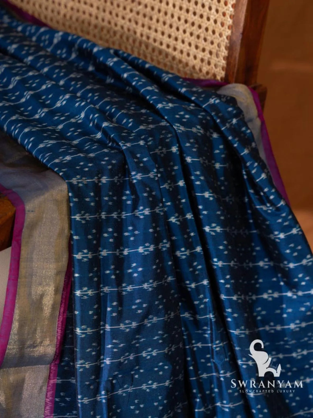 Close-up of white single ikat vine and dot motifs on indigo blue Pochampally silk saree fabric