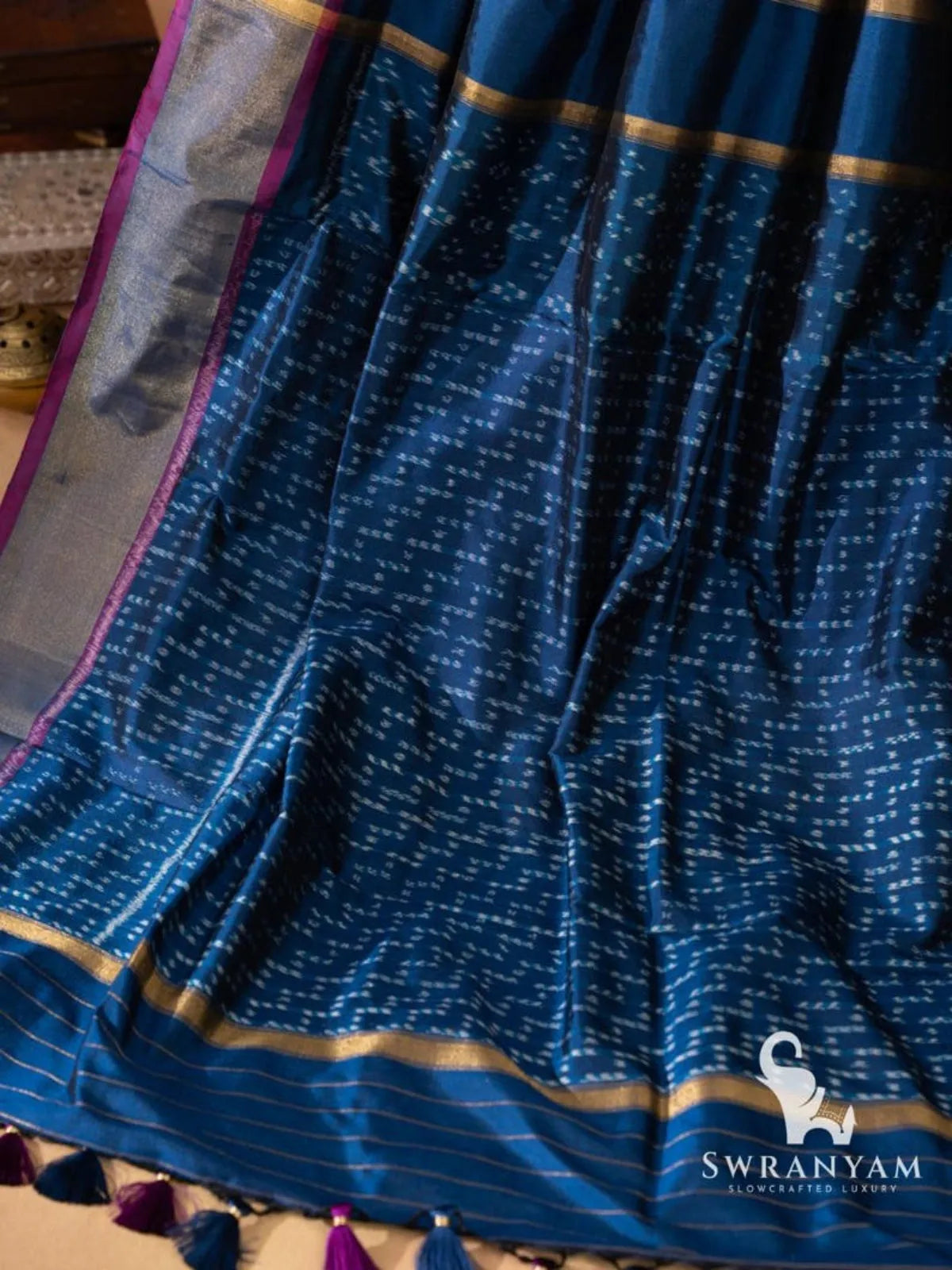 Indigo blue ikat silk saree end with gold zari bands, fine zari stripes and purple and navy tassels