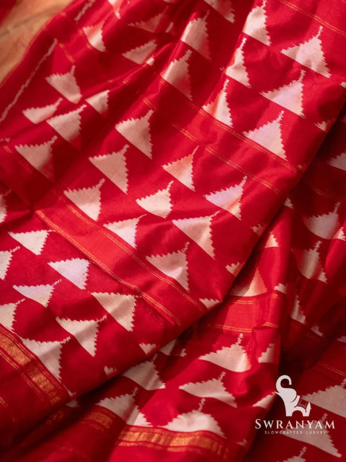 Close-up of white diamond and star ikat motifs on red Pochampally silk saree fabric