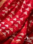 Close-up of white diamond and star ikat motifs on red Pochampally silk saree fabric
