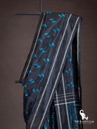 Close-up of black silk saree shoulder drape with blue Z-shaped ikat motifs and silver striped border