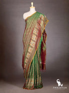 Bottle green maroon dual shade Pochampally ikat silk saree draped on mannequin, front view with ikat border and pallu