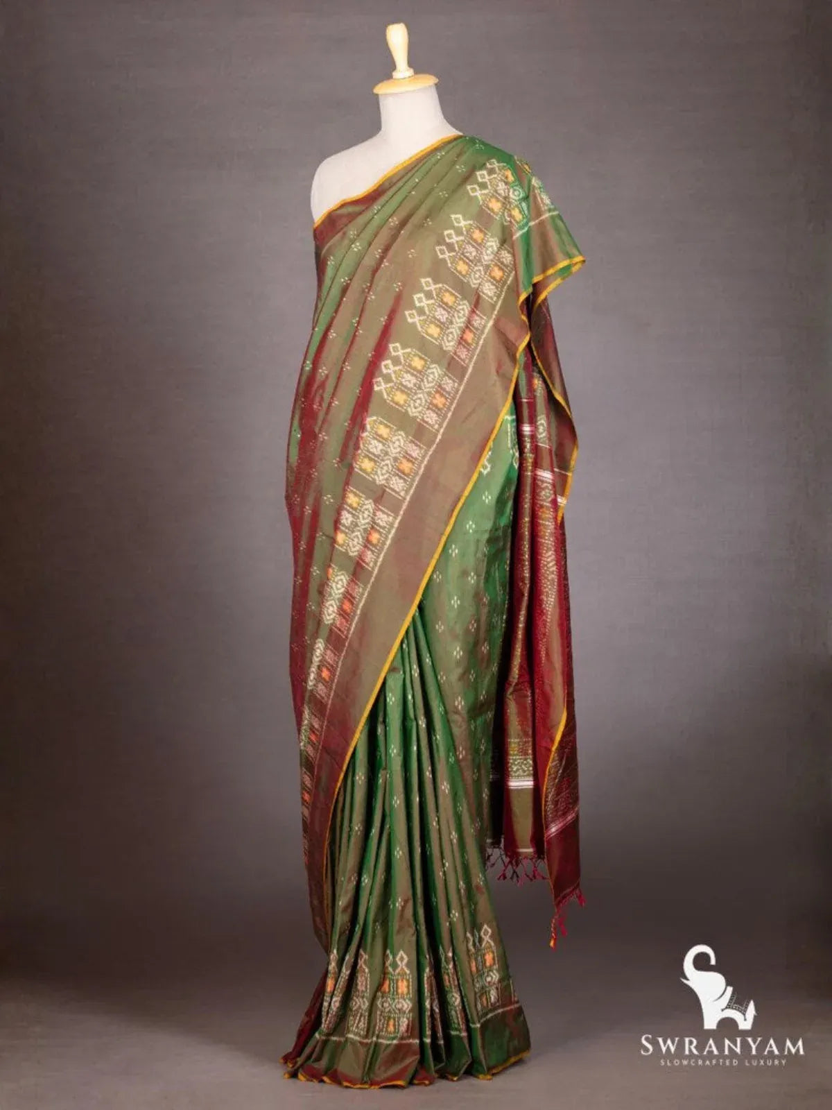 Side view of bottle green maroon Pochampally ikat silk saree with white and orange ikat border motifs