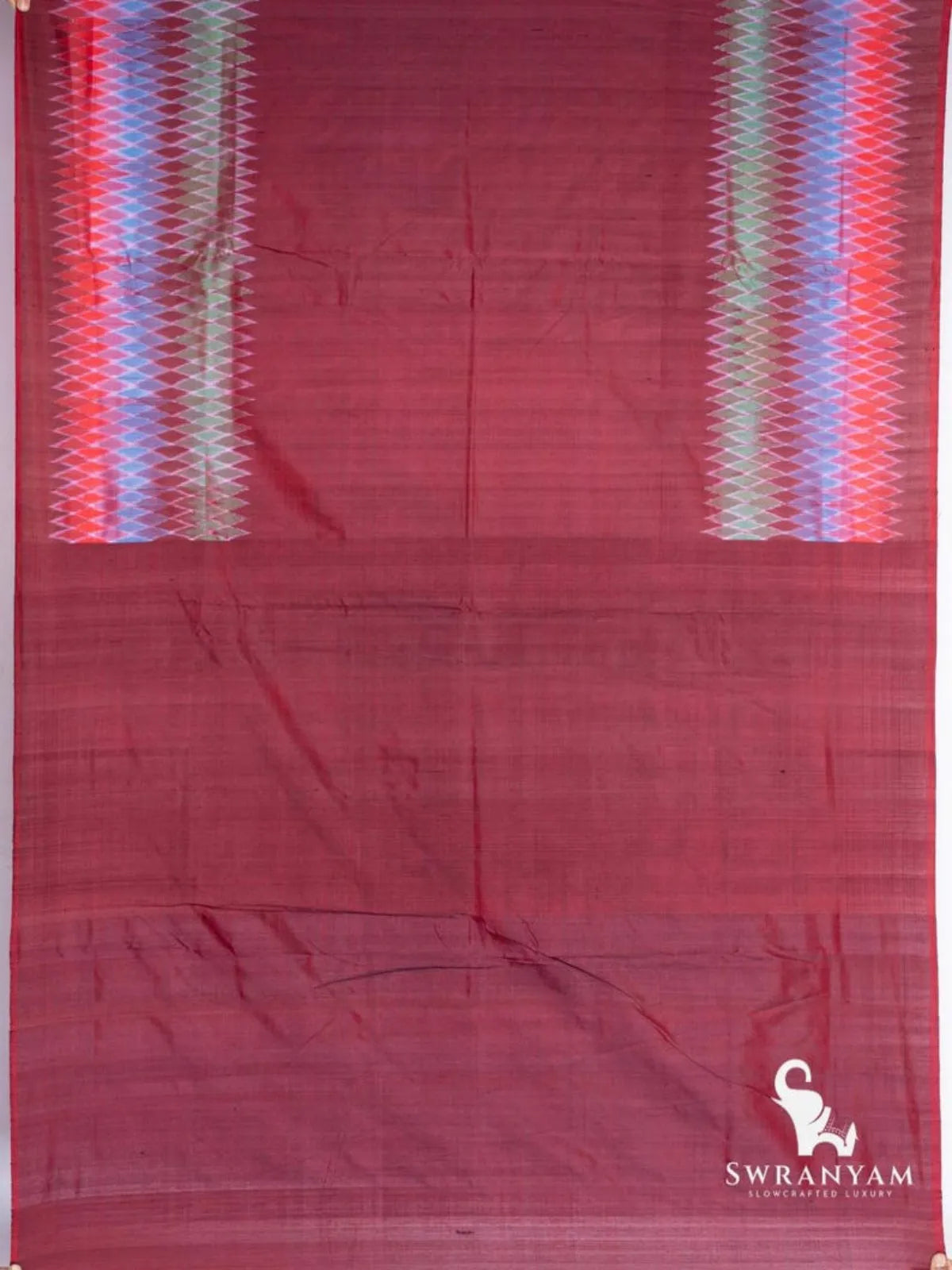 Maroon Pochampally ikat silk saree spread flat showing two multicolour diamond ikat borders and plain maroon end section