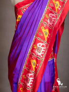 Close-up of red ikat border with white elephant and yellow bird motifs on royal purple silk saree shoulder drape