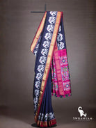 Navy blue Pochampally ikat silk saree with white elephant motifs, gold zari border and pink ikat pallu on stand
