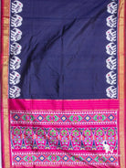 Navy blue ikat silk saree spread flat showing white elephant motif borders, gold zari edges and pink ikat pallu
