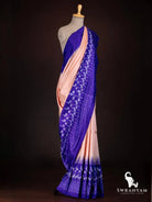 Side view of peach tussar silk ikat saree with royal purple ikat border, paisley motifs and temple border hem on mannequin