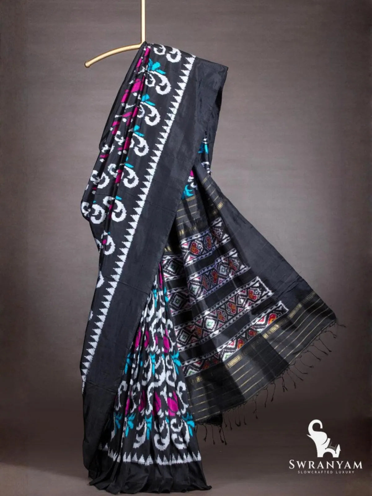 Black ikat silk saree with white temple border and flowing black pallu with multicolour ikat panels and gold zari stripes