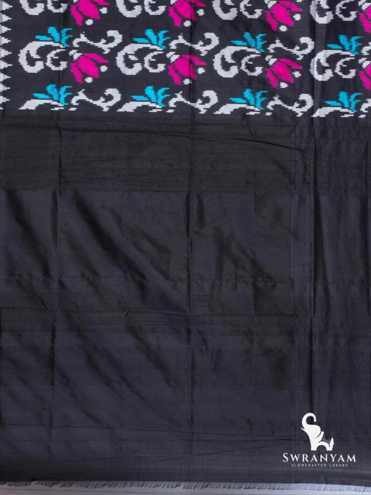 Plain black silk blouse piece at the end of the black Pochampally ikat silk saree with magenta tulip ikat motifs