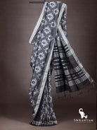 Charcoal grey ikat cotton silk saree with silver striped border and flowing black pallu with silver stripes