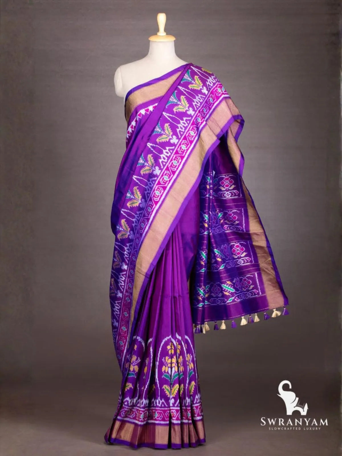 Royal purple ikat silk saree with antique gold zari border and pallu with floral ikat bands and purple and cream tassels