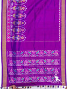 Royal purple Pochampally ikat silk saree spread flat showing floral ikat border, gold zari edges and pallu with ikat bands