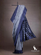 Indigo blue ikat silk saree with white houndstooth body and flowing pallu with diamond ikat motifs and black tassels