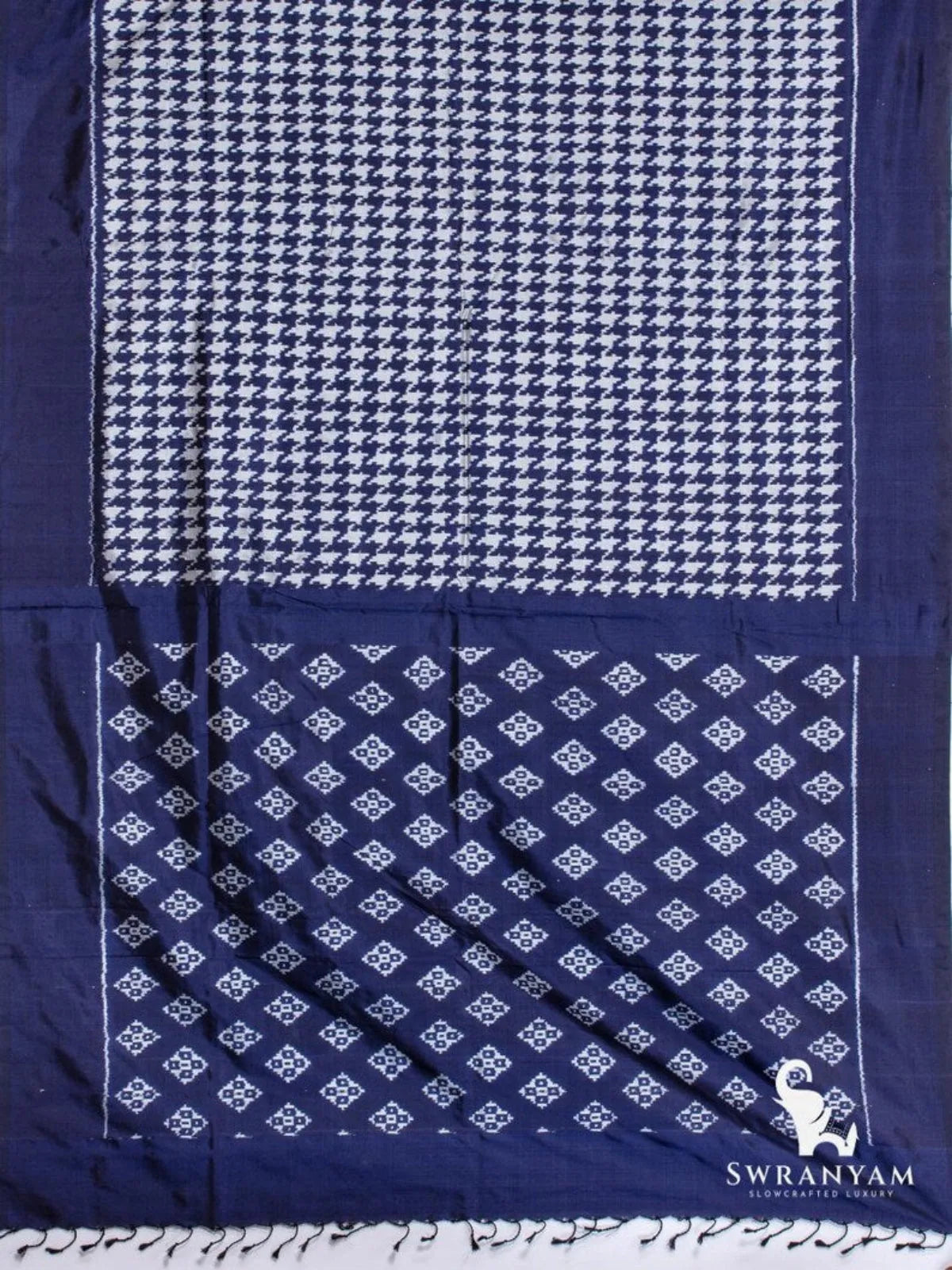 Indigo blue Pochampally ikat silk saree spread flat showing white houndstooth body and pallu with diamond ikat motifs