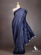 Indigo blue Pochampally ikat silk saree with white chevron motifs draped on mannequin, pallu with blue and white tassels