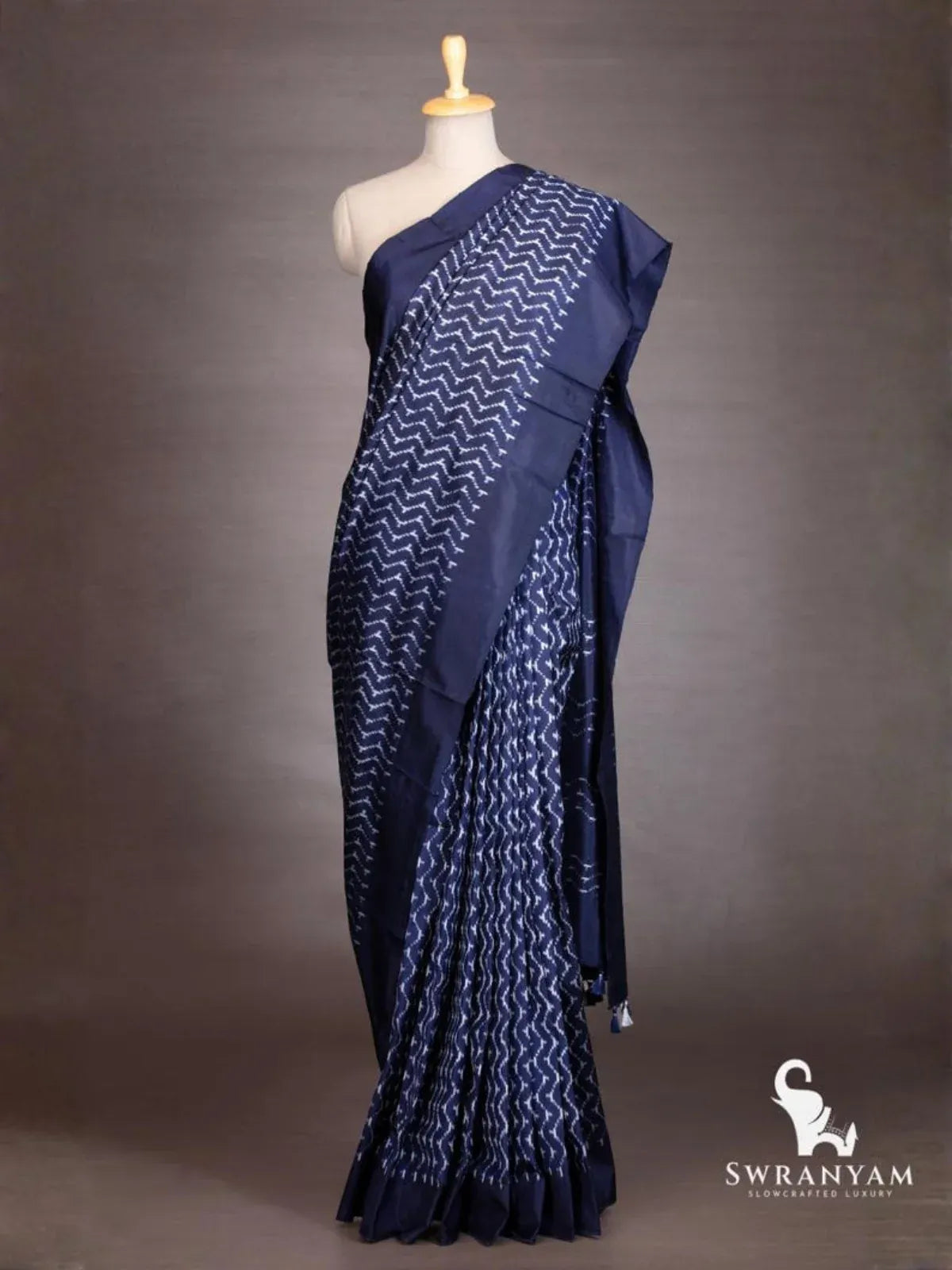 Front view of indigo blue ikat silk saree with white chevron ikat body and solid indigo border on mannequin