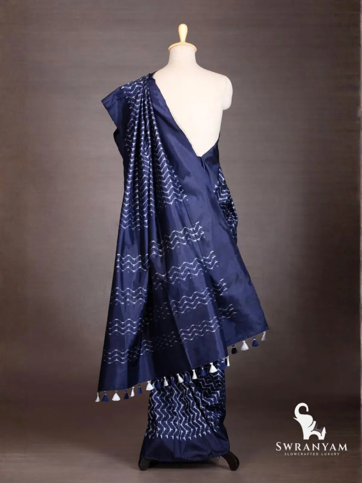 Back view of indigo blue Pochampally ikat silk saree showing pallu with white ikat bands and tassels