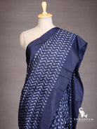 Close-up of white chevron ikat pattern on indigo blue silk saree shoulder drape with solid border