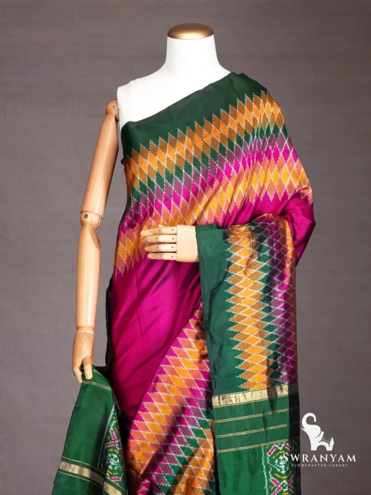 Close-up of wine purple ikat silk saree shoulder drape with mustard, pink and green diamond ikat pattern and zari border