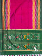 Wine purple ikat silk saree spread flat showing plain body, diamond ikat borders, green pallu with woven motifs and tassels